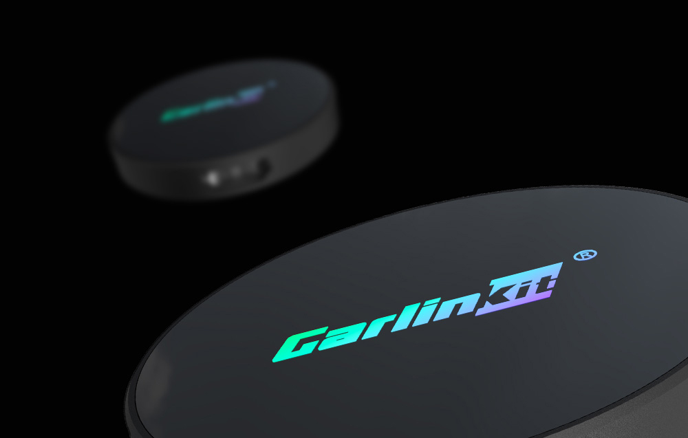Δύο προσαρμογείς Carlinkit σε μαύρο φόντο, ο προσαρμογέας στο προσκήνιο να αναδύεται από τη γωνία, ο άλλος θολωμένος.